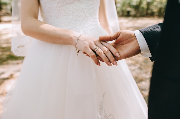 Premium Photo | Loving couple holding hands with rings against wedding ...