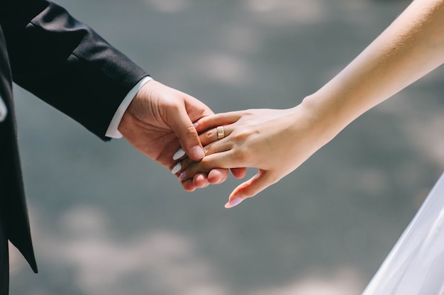 Premium Photo | Loving couple holding hands with rings against wedding ...