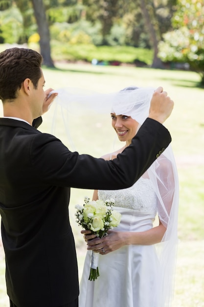 Premium Photo | Loving groom lifting veil of bride