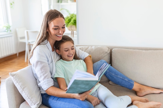 Premium Photo | Loving young mother reading book to adorable little ...