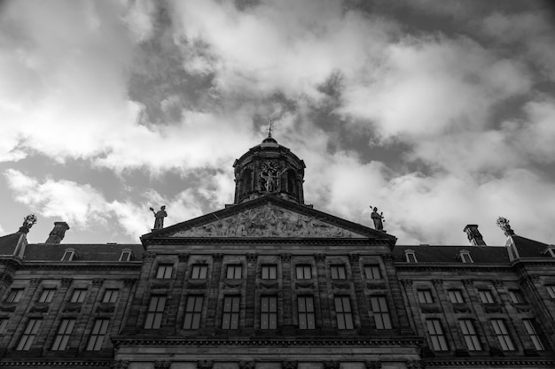 オランダ アムステルダムのダム広場にある王宮のローアングルグレースケールショット 無料の写真