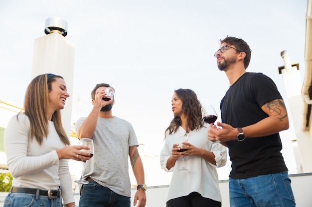 Low Angle Shot Of Smiling People Drinking Red Wine And Talking