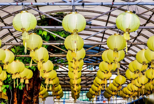 Download Free Photo Low Angle Shot Of Yellow Paper Lanterns Hung From The Metal Bars Of A Ceiling Captured In Laos PSD Mockup Templates
