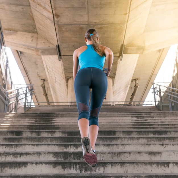 Free Photo | Low angle view of female jogger running on staircase under ...