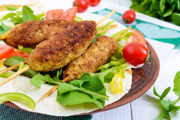 Premium Photo | Lula kebabs on a plate with fresh vegetables