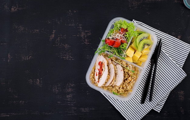 Lunch box chicken, bulgur, microgreens, tomato and fruit. healthy fitness food. take away. lunchbox. top view Free Photo