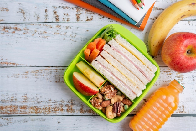 Premium Photo | Lunch box set of ham cheese sandwich with carrot and ...