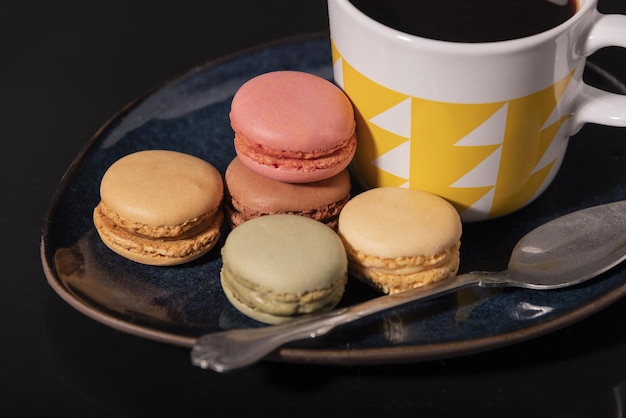 Premium Photo Macarons With Coffee Cup On A Black Background