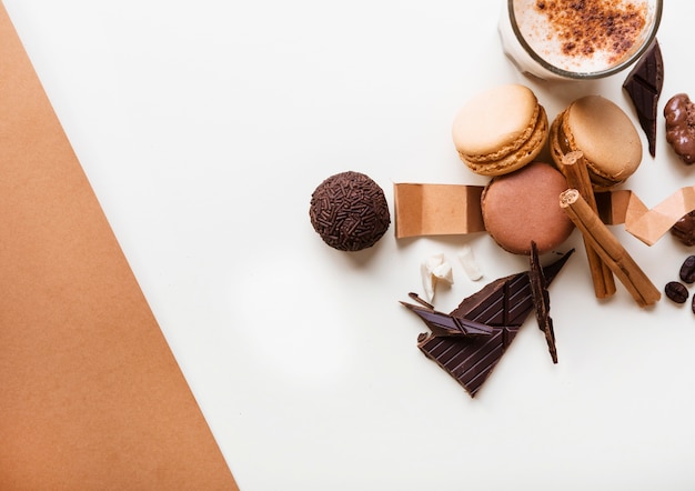 Macaroons; chocolate ball and glass of coffee with ingredients on white background Free Photo