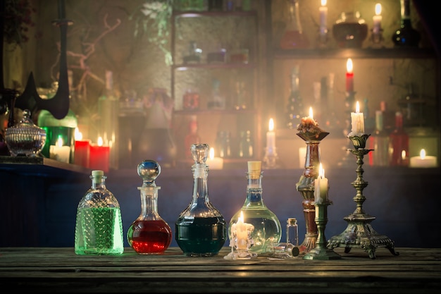 Premium Photo | Magic potions in bottles on wooden background