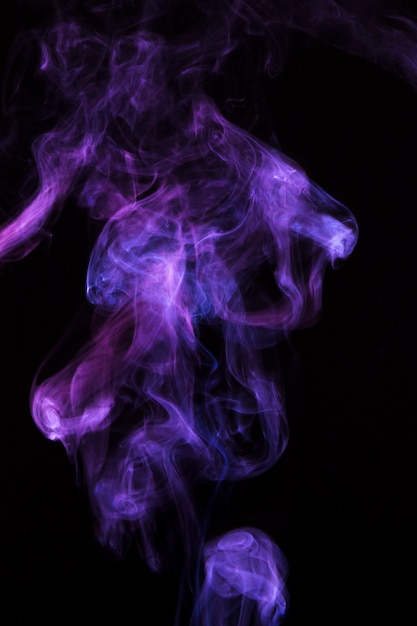 Magical purple smoke spread over black background Photo | Free Download