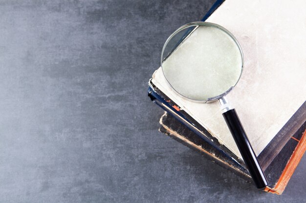 Premium Photo Magnifying Glass On Books On The Table