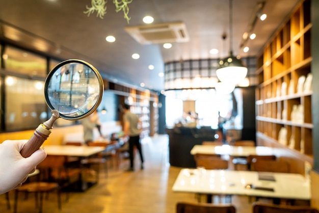 抽象的なぼかしカフェレストランの背景を持つカフェレストラン付きの虫眼鏡 プレミアム写真