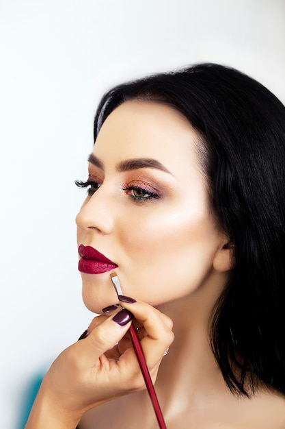 Make up artist applying eye shadow to a woman Premium Photo