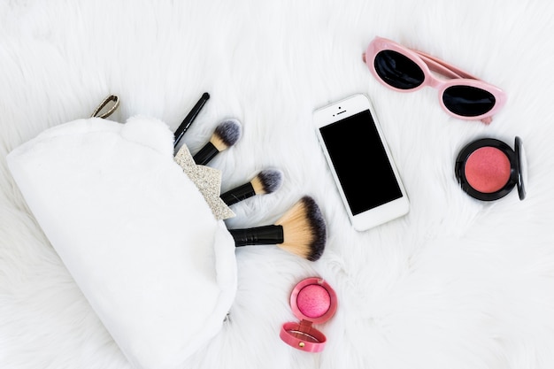 Free Photo | Makeup brushes in bag; mobile phone; sunglasses and pink ...