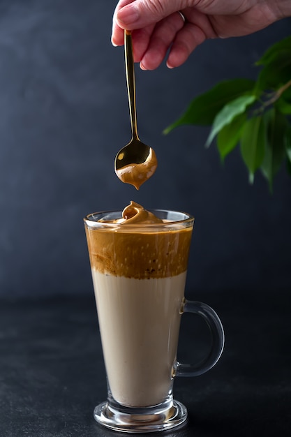 Premium Photo Making Dalgona Coffee Hand With A Spoon Of Whipped Foam