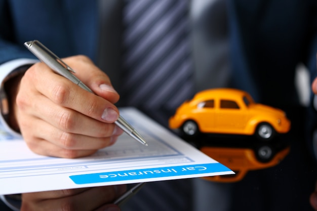 Male arm in suit sign insurance form lying on table Premium Photo