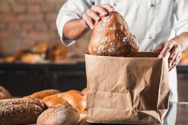 putting baked bread in brown paper bag