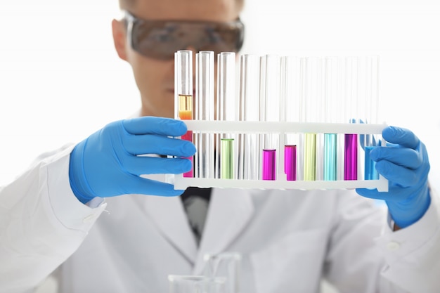 Premium Photo A Male Chemist Holds Test Tube Of Glass In His Hand Overflows A Liquid Solution