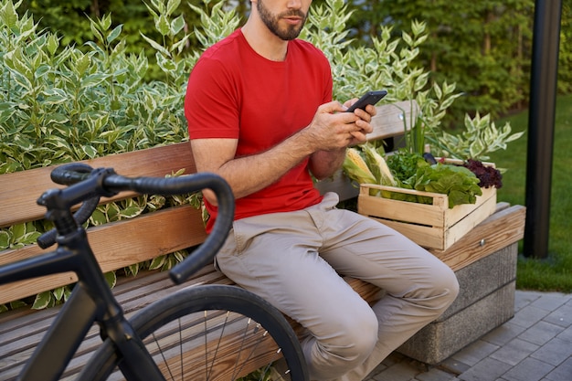 Premium Photo Male Courier In Uniform Sitting On The Bench Outdoors