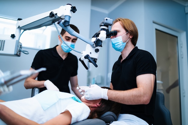 Premium Photo | Male dentists and a patient in dentistry office