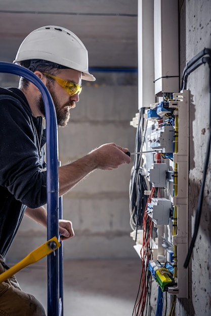 Free Photo | A male electrician works in a switchboard with an ...