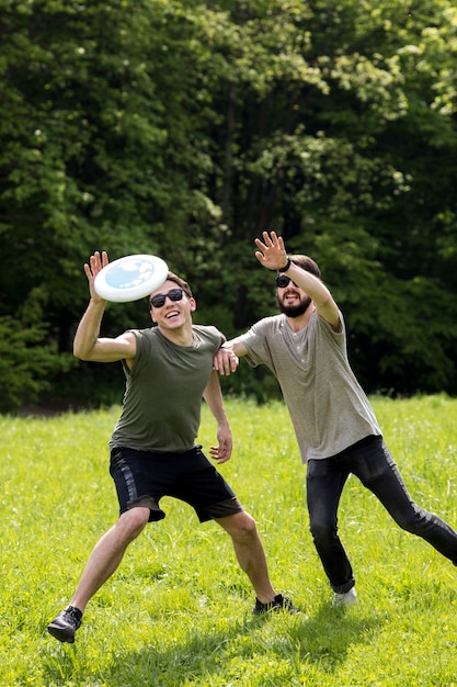 Free Photo | Male friends enjoying frisbee game in park