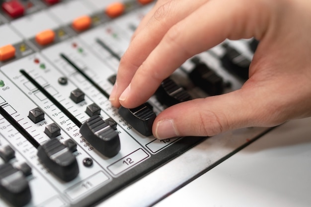 Male Hand On Control Fader On Console Sound Recording Studio