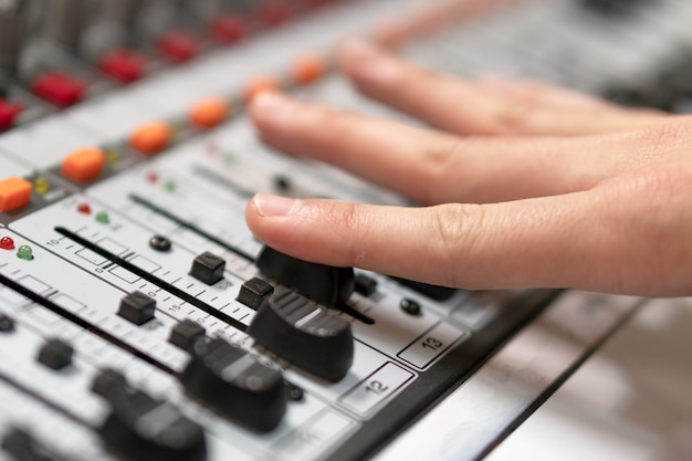Male Hand On Control Fader On Console Sound Recording Studio