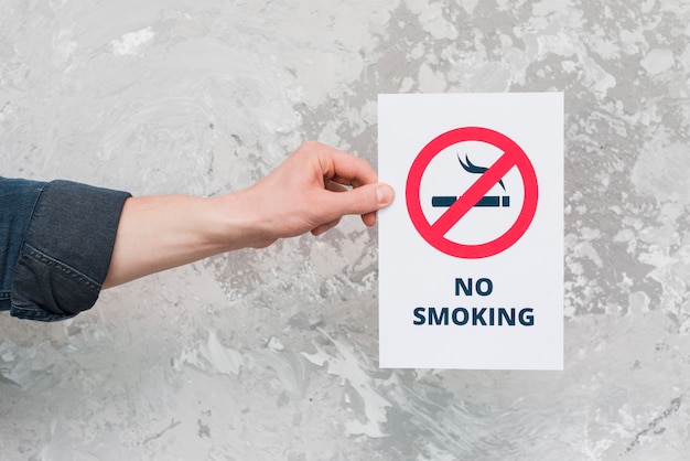 Male Hand Holding Paper With No Smoking Sign And Text Over