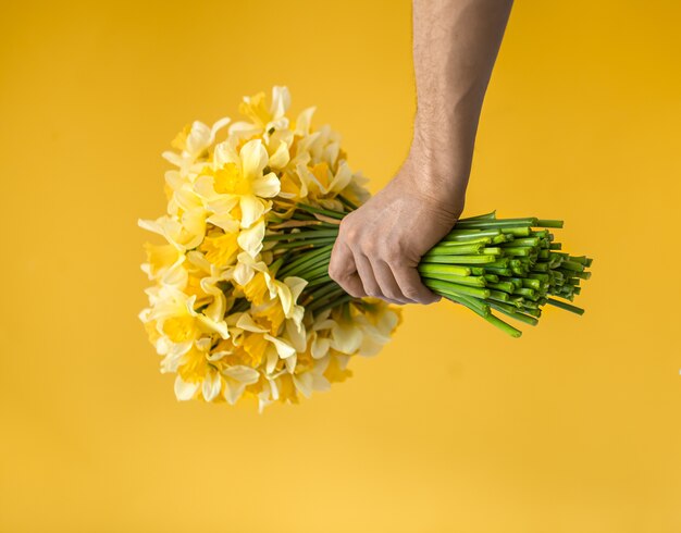 黄色い水仙の花束を持つ男性の手 無料の写真