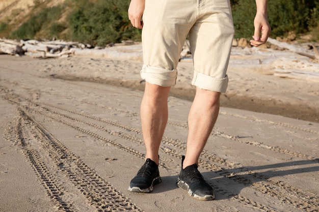 Premium Photo | Male legs in beige horts walking along the beach