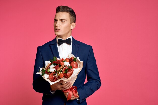 花の花束を持つ古典的なビジネススーツでポーズをとる男性モデル プレミアム写真