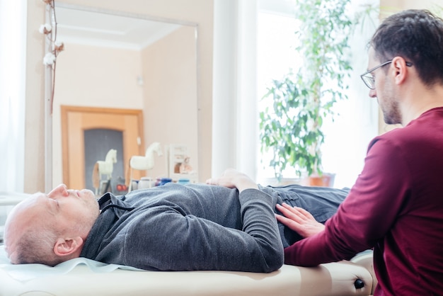 Premium Photo | Male patient receiving cranial sacral therapy, lying on ...