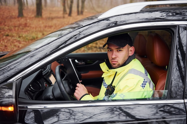 Premium Photo | Male police officer in green uniform sitting in ...