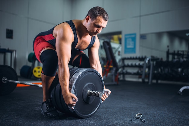 Premium Photo | Male powerlifter prepares a barbell in gym