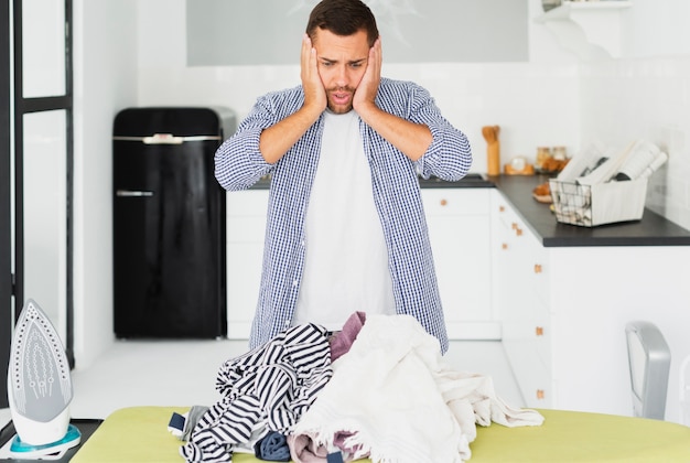 Male in shock from all the clothes to iron Photo | Free Download