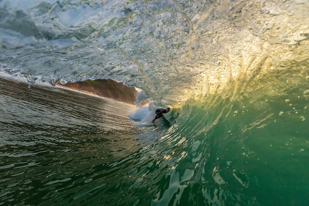 ポルトガル アルガルヴェの海の強い波を乗っ取るトリックをしている男性サーファー 無料の写真
