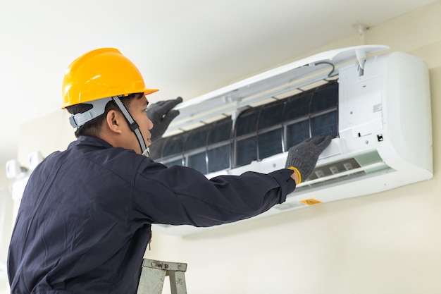 Premium Photo | Male technician repairing air conditioner safety ...