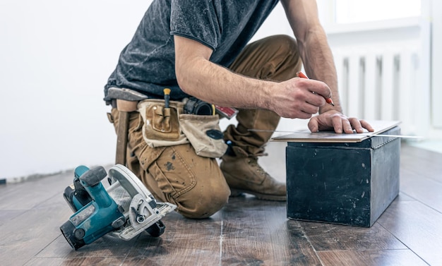 Premium Photo | A male worker puts laminate flooring on the floor