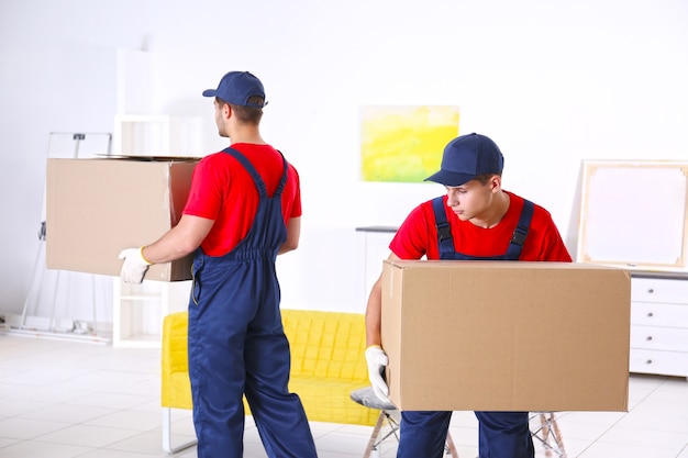 Premium Photo | Male workers with boxes and furniture in new house