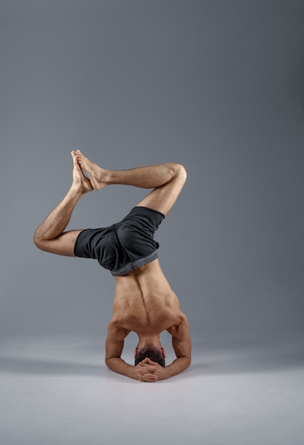 Premium Photo | Male yoga standing on his head and elbows, back view ...