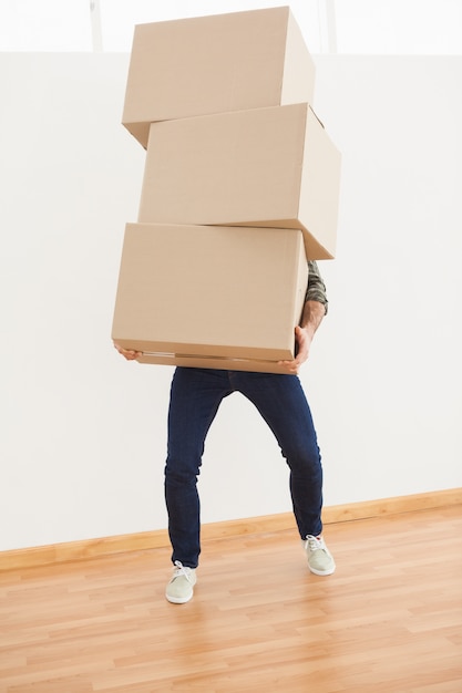 Premium Photo | Man balancing heavy cardboard boxes