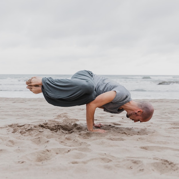 Premium Photo | Man on the beach practicing yoga