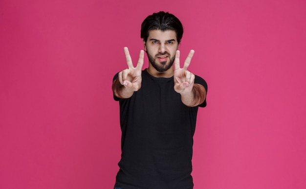 Free Photo Man In Black Shirt Making Peace Hand Sign 8274