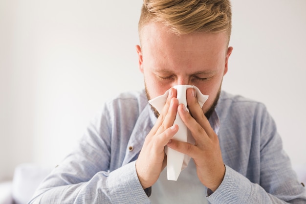 Free Photo | Man blowing nose with eyes closed