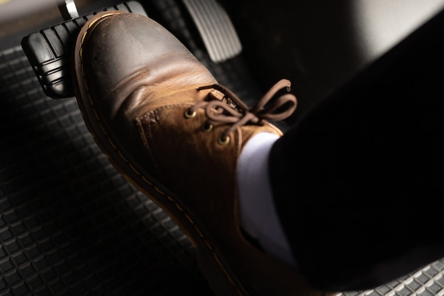 Premium Photo | A man in brown leather shoes is stepping on the ...