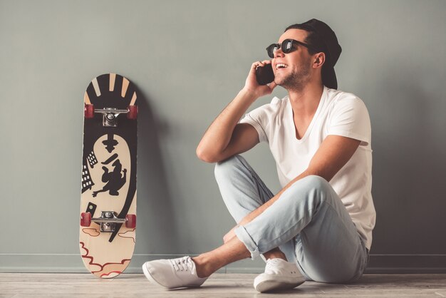 Man in cap and sunglasses is talking on the mobile phone Premium Photo