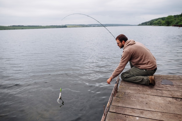 Free Photo | Man catching fish with fishing rod in lake