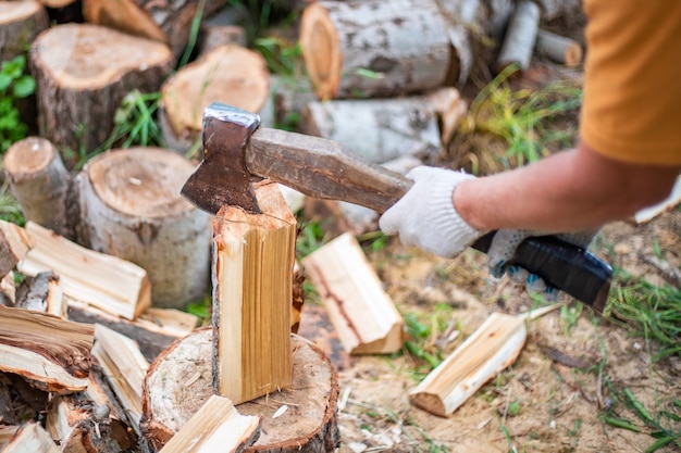 Premium Photo | A man chops wood with a large ax procurement of fuel ...